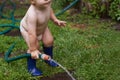 Hosepipe horseplay. A young toddler standing outside playing with a hosepipe. Royalty Free Stock Photo