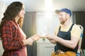 Hospitable lady giving coffee to repairman Royalty Free Stock Photo