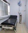 hospital bed with oxygen tank and fan on the wall
