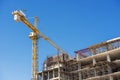 Hospital building under construction with cranes against a blue sky.