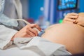 In the Hospital, Close-up Shot of the Doctor does Ultrasound Sonogram Procedure to a Pregnant Woman. Obstetrician Moving