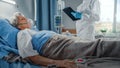 Hospital Coronavirus Emergency Department Ward: Doctor wearing Coverall Writes Down Vitals of a Royalty Free Stock Photo