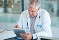 Hospital, doctor and senior man on tablet for medical analysis, research and report. Healthcare, clinic and elderly male Royalty Free Stock Photo