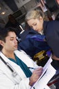 Hospital doctor taking notes paramedics