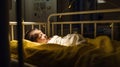 Sleeping baby boy in hospital bed with lights on background Royalty Free Stock Photo