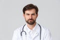 Hospital, healthcare workers, covid-19 treatment concept. Close-up of serious, determined bearded doctor in white scrubs