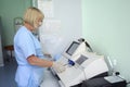 At a hospital laboratory. Lab technician performing analysis of blood samples with gas-electrolyte analyzer