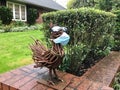 Hospital mask on metal chicken sculpture in Portland, Oregon front yard.