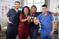 Mixed race African and Indian Asian doctors showing their stethoscopes to camera and smiling Royalty Free Stock Photo