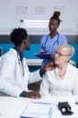 Hospital otologist discussing with nurse about complex patient ear infection and pain Royalty Free Stock Photo
