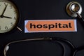 Hospital on the print paper with Healthcare Concept Inspiration. alarm clock, Black stethoscope. Royalty Free Stock Photo