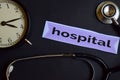 Hospital on the print paper with Healthcare Concept Inspiration. alarm clock, Black stethoscope. Royalty Free Stock Photo