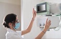 Hospital Radiology Room: Beautiful Multiethnic Woman adjusting X-Ray Machine in Modern Clinic Office. technician in