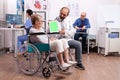 Hospital staff consulting handicapped senior woman