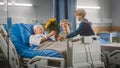 Hospital Ward: Elderly Man Resting in Bed, His Caring Beautiful Wife Supports Him by Sitting Besid Royalty Free Stock Photo