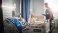 Hospital Ward: Handsome Young Boy Resting in Bed with Caring Mother Visits to Support Him, Friendl Royalty Free Stock Photo
