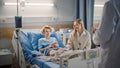 Hospital Ward: Handsome Young Boy Resting in Bed with Caring Mother Visits to Support Him, Friendl Royalty Free Stock Photo