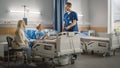 Hospital Ward: Handsome Young Boy Resting in Bed with Caring Mother Visits to Support Him, Friendl Royalty Free Stock Photo