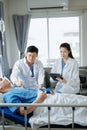 Hospital Ward Male and Female Professional Caucasian Doctors Talk with a Patient, Give Health Care Advice, Recommend Treatment Royalty Free Stock Photo