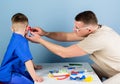 Hospital worker. Medical service. Man doctor sit table medical tools examining little boy patient. Health care Royalty Free Stock Photo