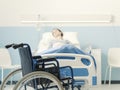 Hospitalized patient lying in bed and wheelchair Royalty Free Stock Photo