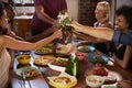 Host and friends making a toast at a dinner party, close up