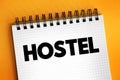 Hostel - low-cost, short-term shared sociable lodging where guests can rent a bed, text concept on notepad