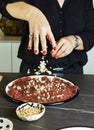 Hostess making carpaccio in home kitchen with fresh ingredients on black marble