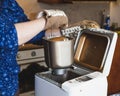 Hostess takes fresh bread from an electric bread machine Royalty Free Stock Photo