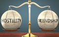 Hostility and friendship staying in balance - pictured as a metal scale with weights and labels hostility and friendship to