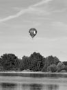 A hot air ballon flies above water