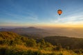 Hot air balloon above high mountain at sunset