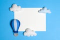 Hot air balloon in blue sky with clouds, frame, copyspace. Hand made felt toys. Royalty Free Stock Photo