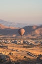 Hot air balloon with checkered pattern rising over the Cappadocian valley