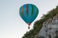 Hot air balloon close to cliff face