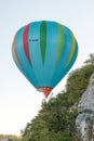 Hot air balloon close to cliff face