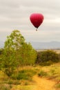 Hot air balloon drifting over fields.