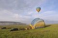 Hot-air balloon drifting in the sky, car and equipment set on the ground