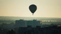 Hot air balloon early in the morning over residential buildings