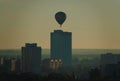 Hot air balloon early in the morning over residential buildings