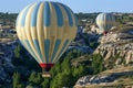 A hot air balloon flies down Love Valley at sunrise near Goreme in the Cappadocia region of Turkey.