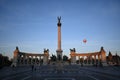 Hot air balloon flies by Heroes' Square before the blue skyline in Budapest