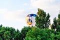 Hot air balloon floating behind the trees in the sky during European Balloon Festival in Barcelona