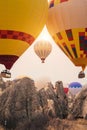 Hot air balloon flying over Cappadocia mountain landscape at gold sunrise Royalty Free Stock Photo