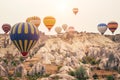 Hot air balloon flying over Cappadocia mountain landscape at gold sunrise Royalty Free Stock Photo