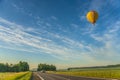 Hot air balloon flying over the road Royalty Free Stock Photo