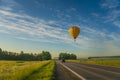 Hot air balloon flying over the road
