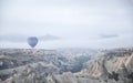 Hot air balloon flying over rocks and valley landscape at Cappadocia near Goreme Turkey Royalty Free Stock Photo