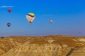 Hot air balloon flying over rocky landscape at sunrise - Cappadocia Turkey Royalty Free Stock Photo