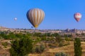 Hot air balloon flying over rocky landscape at sunrise - Cappadocia Turkey Royalty Free Stock Photo